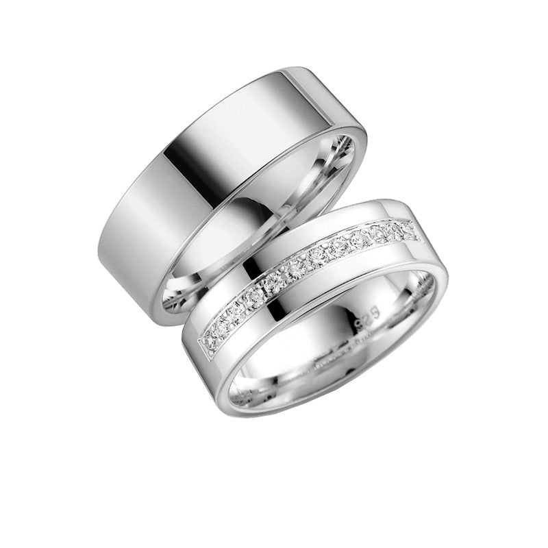 Tidløs Aagaard vielsesringe i sterlingsølv med 7 mm bredde, damering med kubiske zirkonia og blankpoleret herrering.